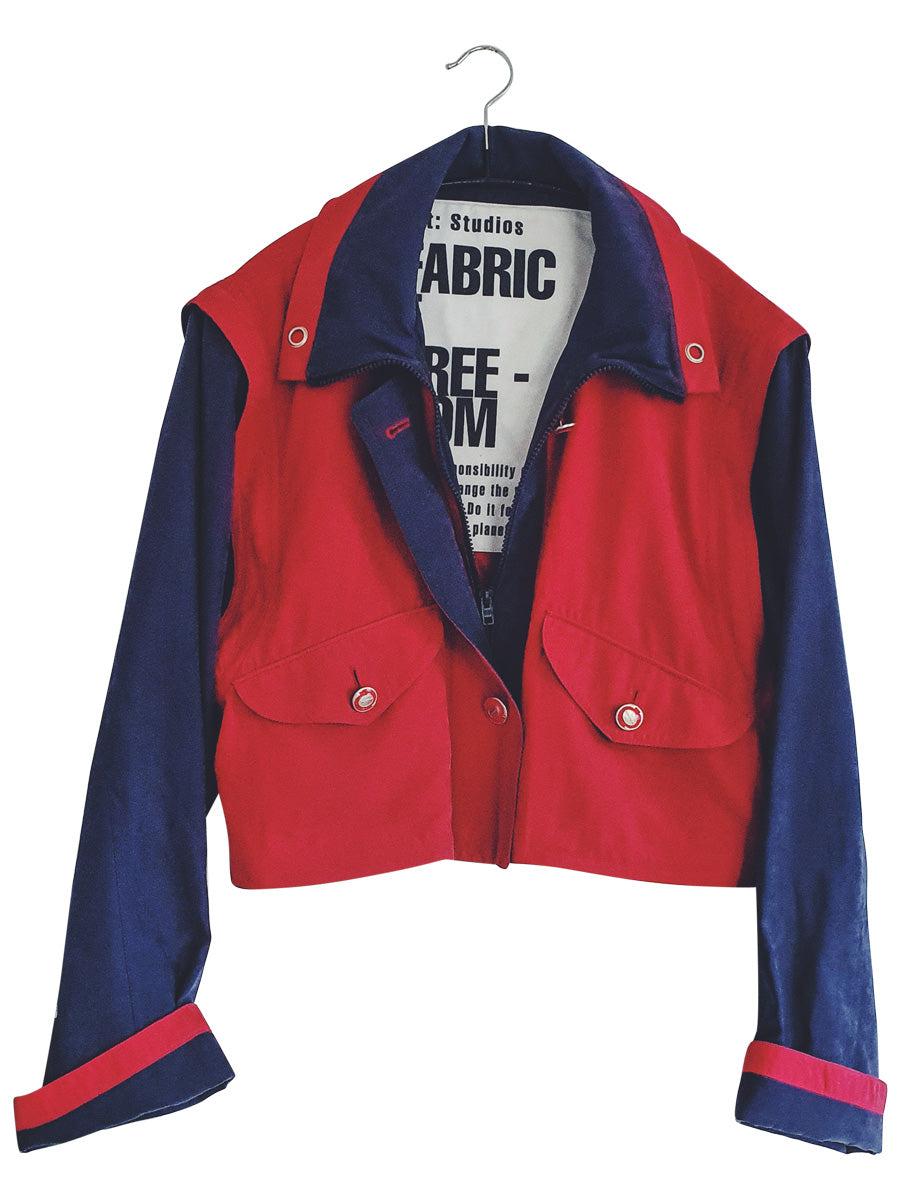 Upcycled red and navy waterproof short coat with removable sleeves, this jacket can also be worn as a gilet. Crafted by Fanfare artisans in our sustainable London-based factories.