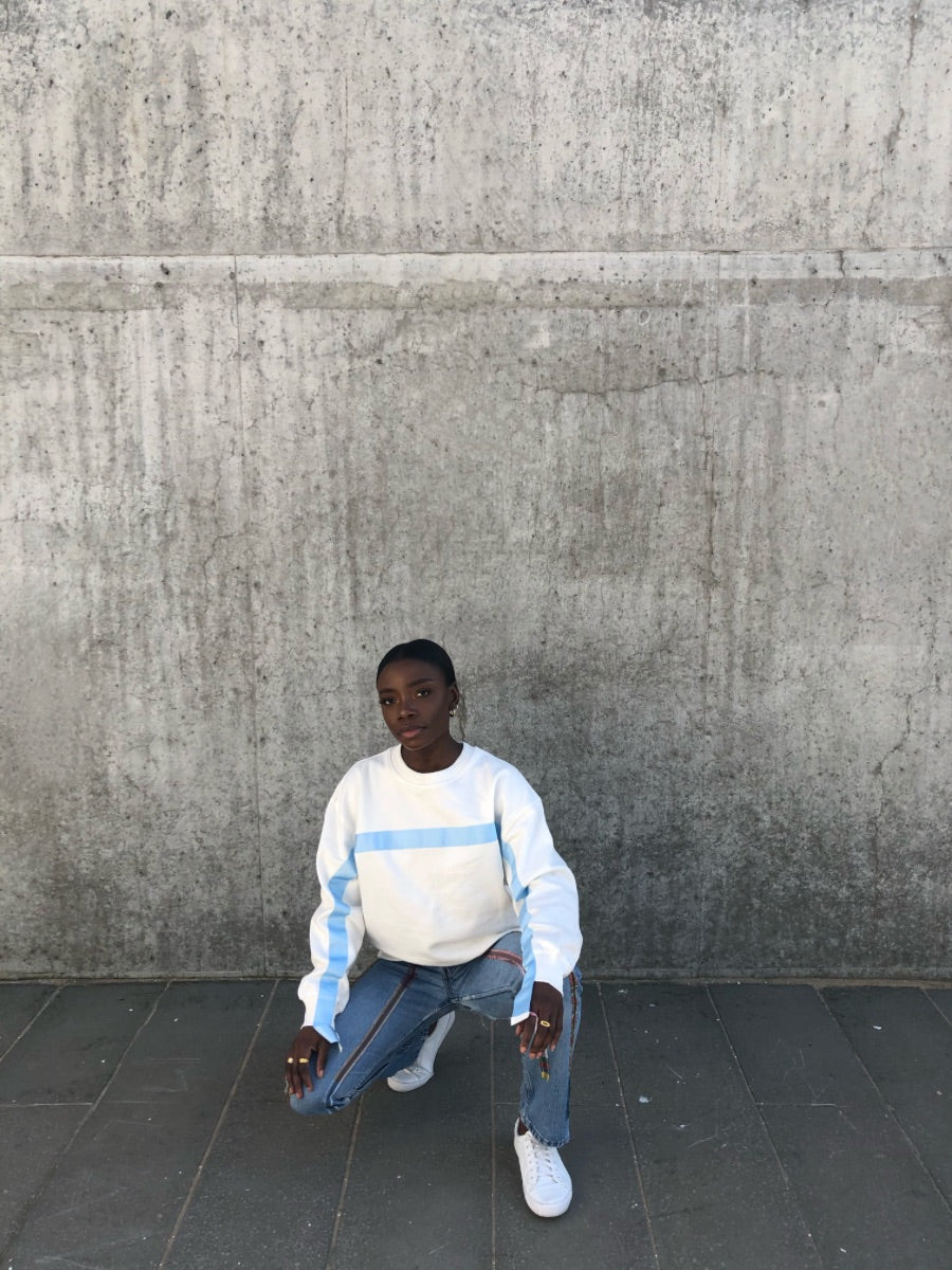100% Gots certified organic cotton jumper in white with an blue stripe across the chest & down the arms. Made by sustainable clothing brand Fanfare Label.