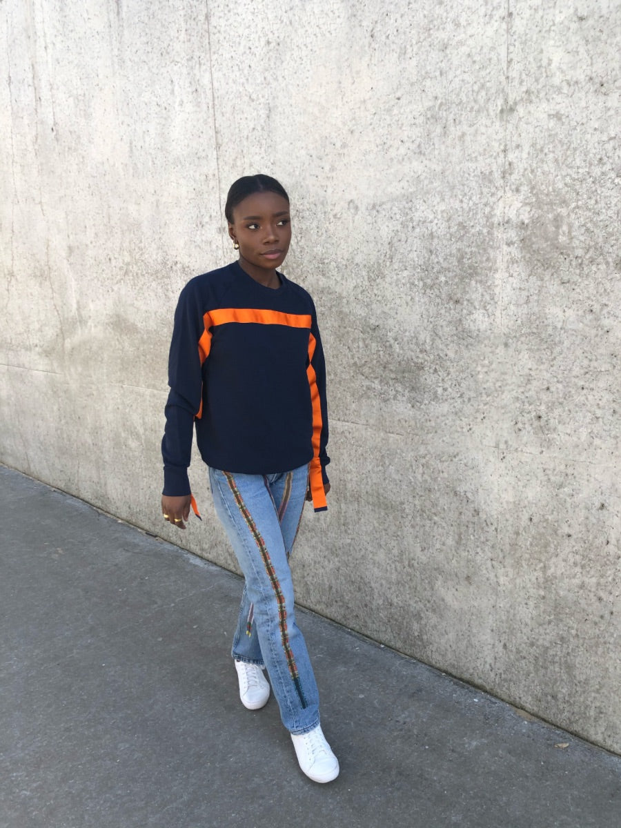 100% Gots certified organic cotton jumper in navy with an orange stripe across the chest & down the arms. Made by sustainable clothing brand Fanfare Label.