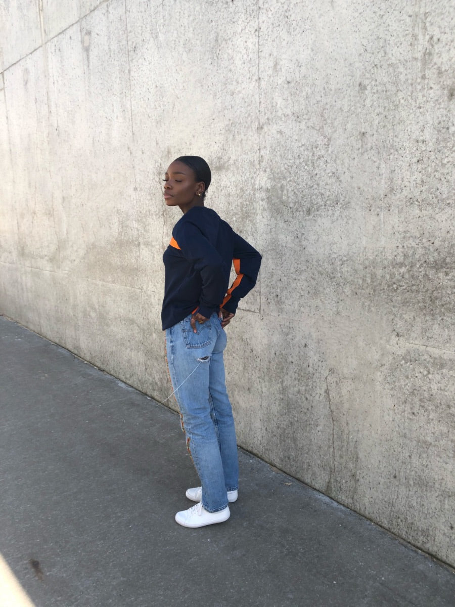 100% Gots certified organic cotton jumper in navy with an orange stripe across the chest & down the arms. Made by sustainable clothing brand Fanfare Label.