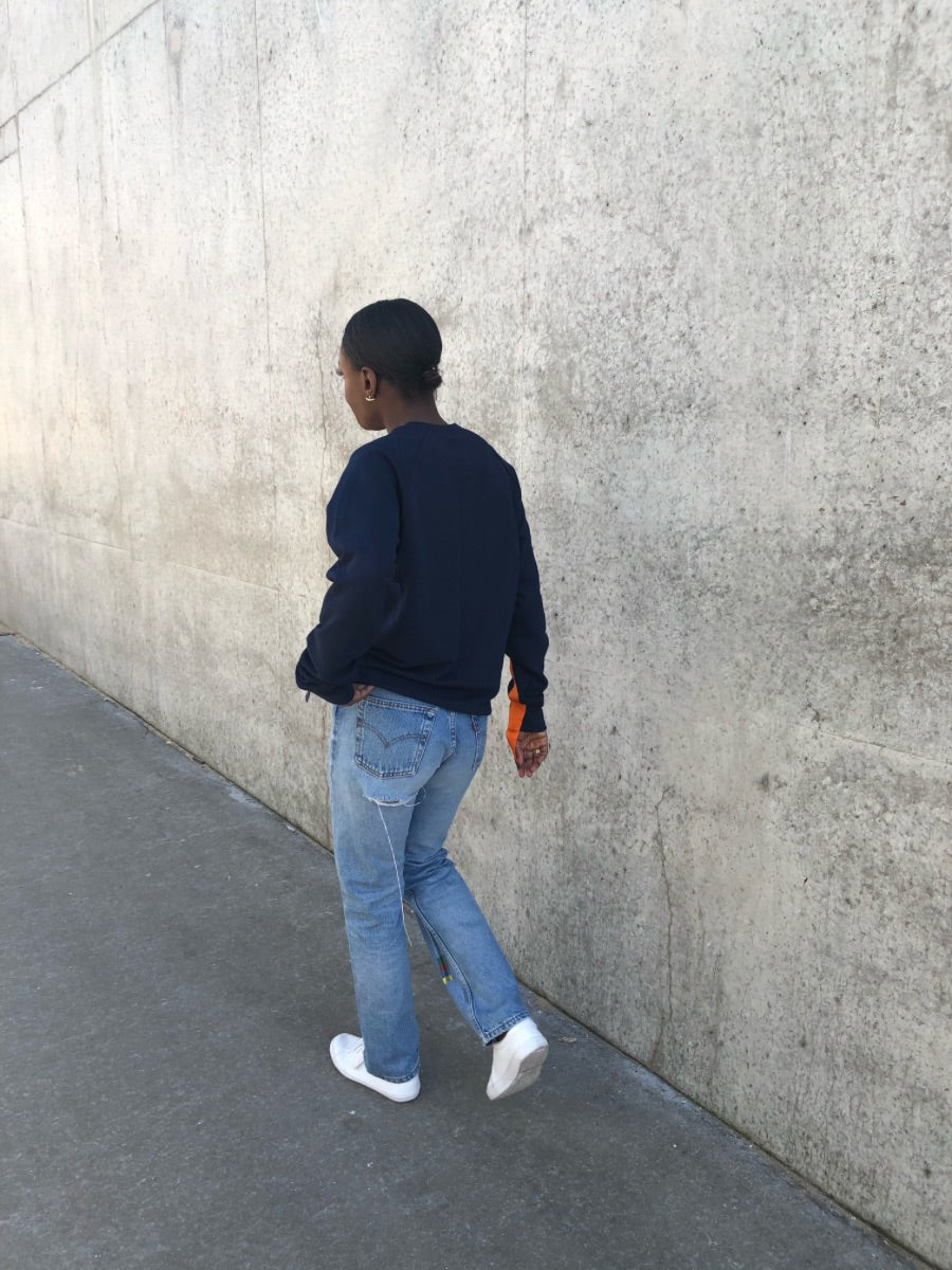 100% Gots certified organic cotton jumper in navy with an orange stripe across the chest & down the arms. Made by sustainable clothing brand Fanfare Label.