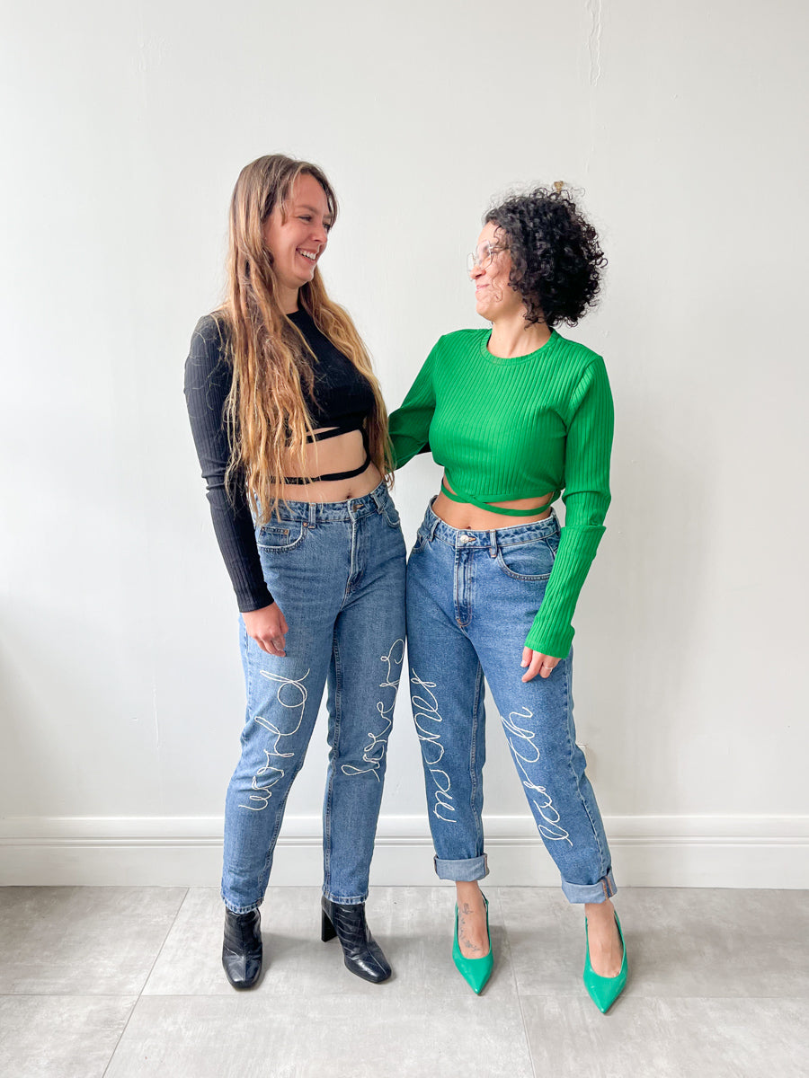 Upcycled jeans embroidered with the words 'Mother Earth'. A one-of-a-kind designer piece handmade in the UK by sustainable womenswear brand Fanfare in our ethical London factories.