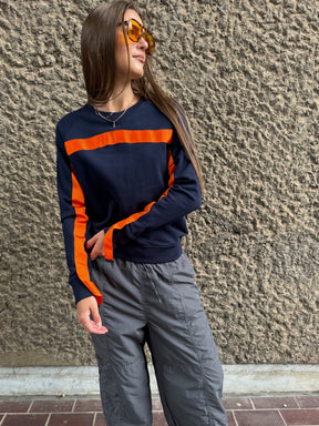 100% Gots certified organic cotton jumper in navy with an orange stripe across the chest & down the arms. Made by sustainable clothing brand Fanfare Label.