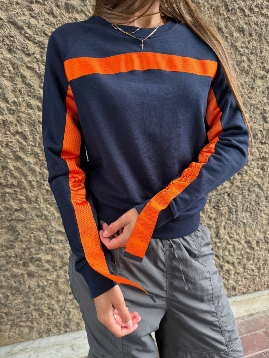 100% Gots certified organic cotton jumper in navy with an orange stripe across the chest & down the arms. Made by sustainable clothing brand Fanfare Label.