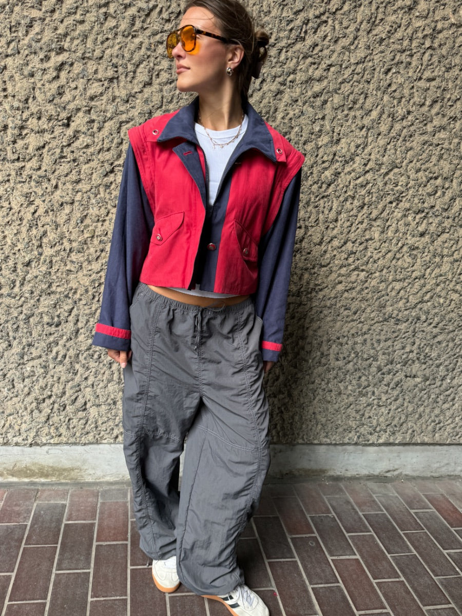 Upcycled red and navy waterproof short coat with removable sleeves, this jacket can also be worn as a gilet. Crafted by Fanfare artisans in our sustainable London-based factories.