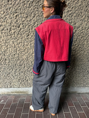 Upcycled red and navy waterproof short coat with removable sleeves, this jacket can also be worn as a gilet. Crafted by Fanfare artisans in our sustainable London-based factories.