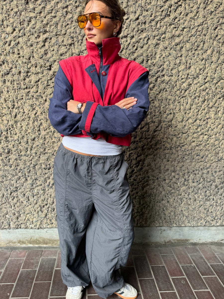 Upcycled red and navy waterproof short coat with removable sleeves, this jacket can also be worn as a gilet. Crafted by Fanfare artisans in our sustainable London-based factories.