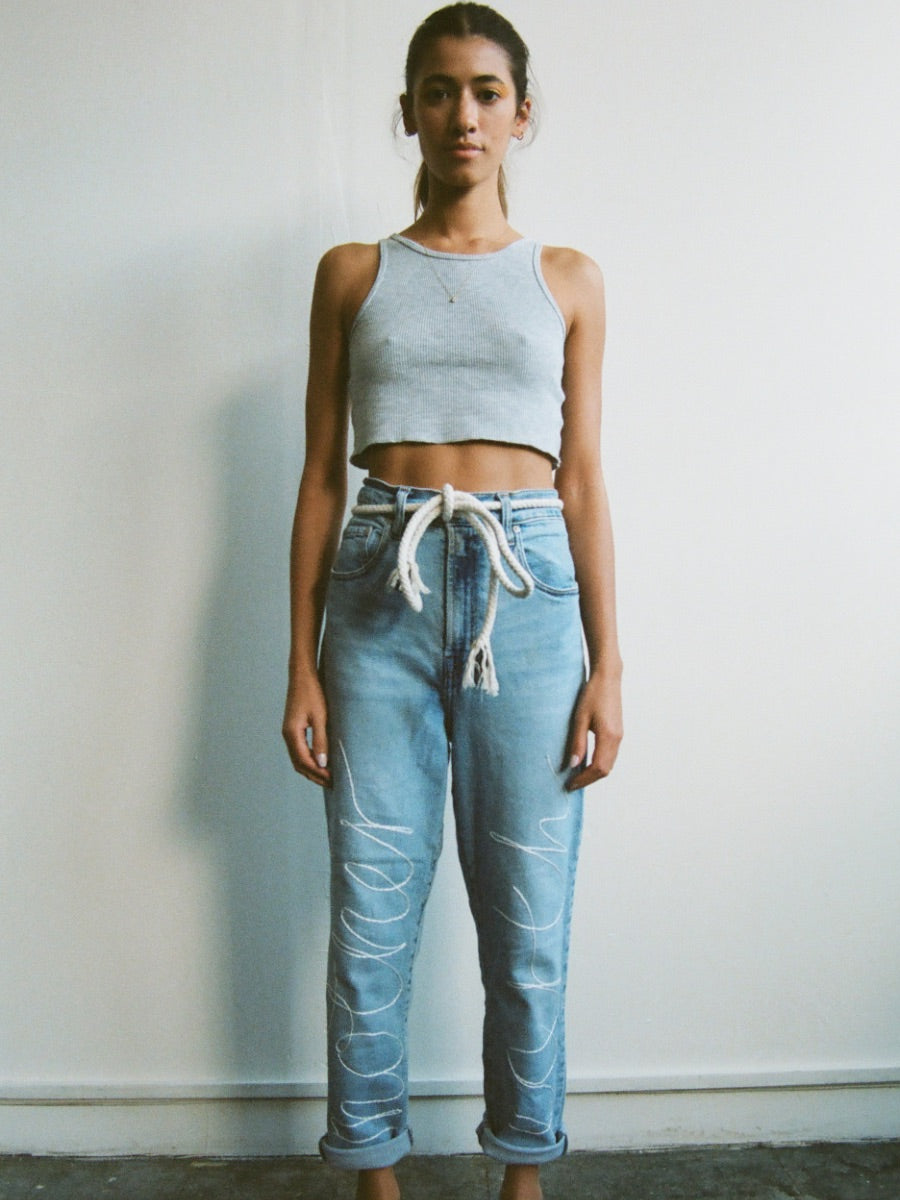 Upcycled jeans embroidered with the words 'Mother Earth'. A one-of-a-kind designer piece handmade in the UK by sustainable womenswear brand Fanfare in our ethical London factories.